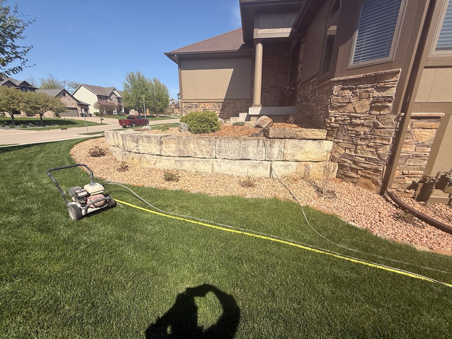 Stone retaining wall and cleaning equipment beside a Des Moines home
