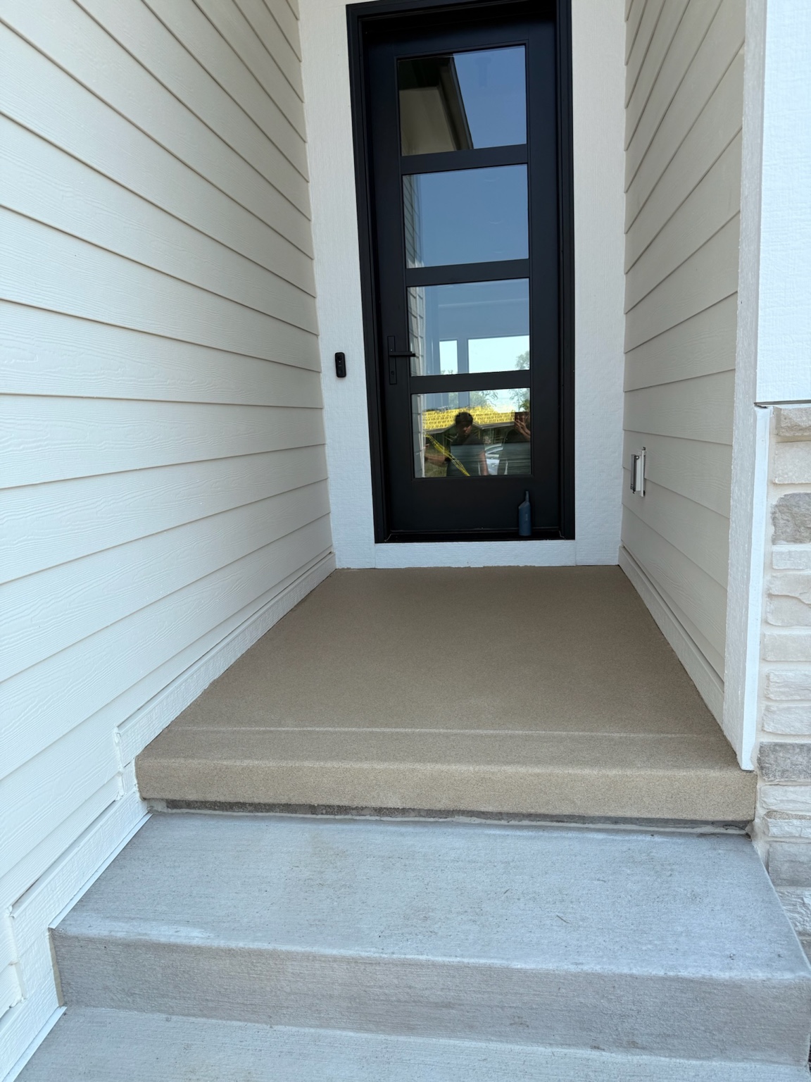 Tan concrete coating on the front entry and doorstep of a Waterloo home
