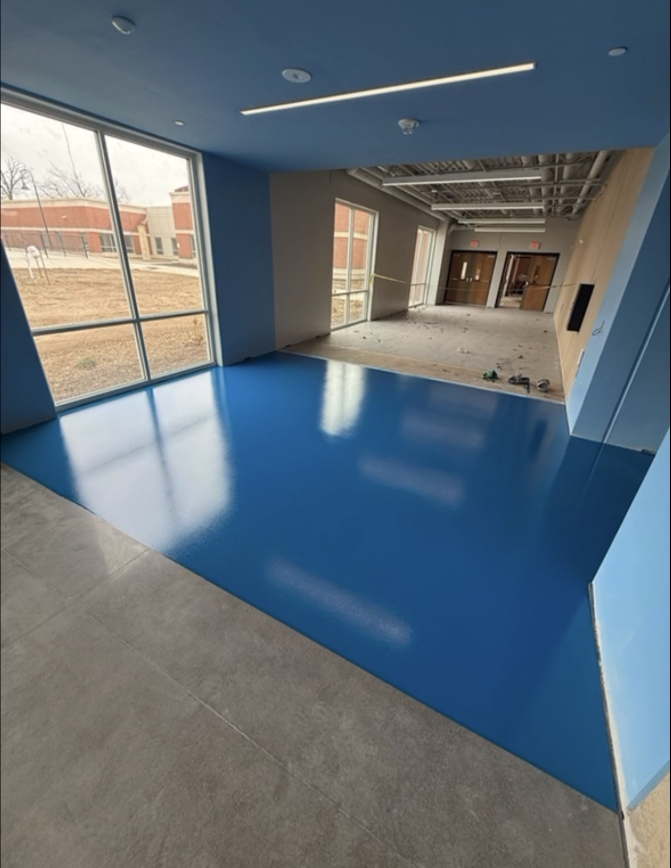 Glossy blue epoxy floor coating finished in a Waterloo, Iowa commercial building