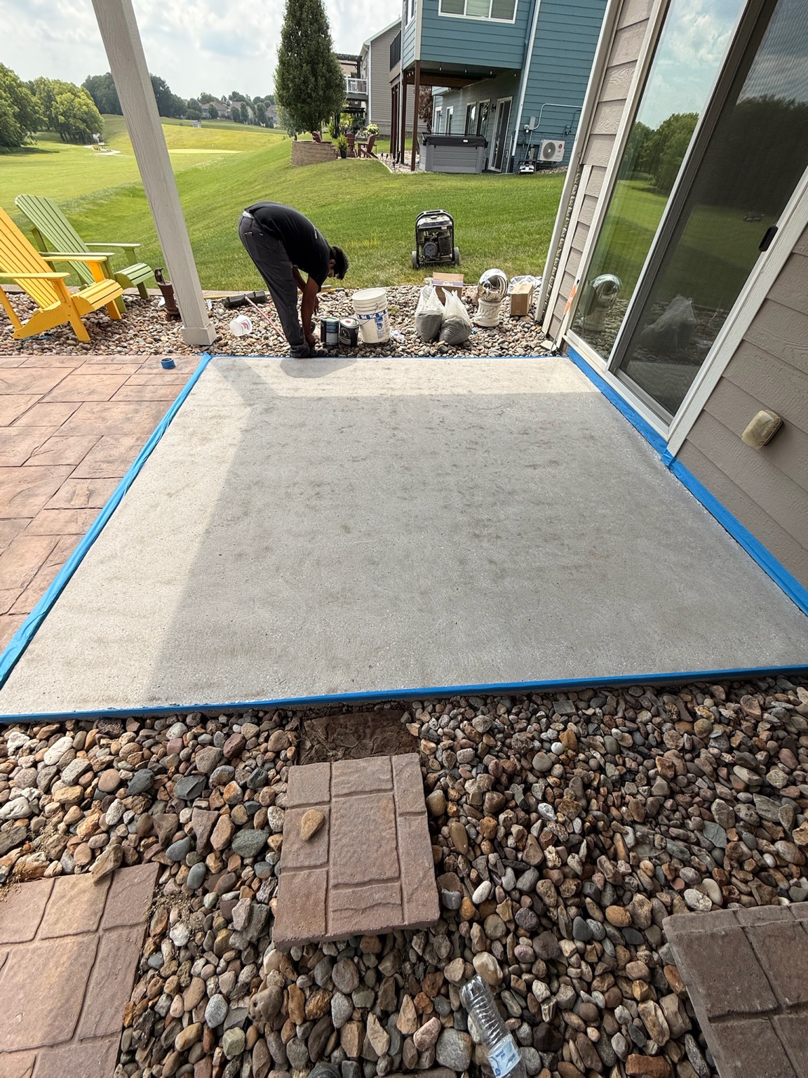 Concrete patio masked along its edges for surface preparation at a Waterloo home
