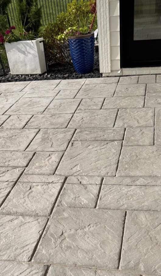 Stamped concrete patio with a textured stone-block pattern before resealing